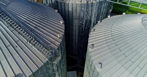 Commercial Grain Or Seed Silos In Sunny Spring Rural Landscape