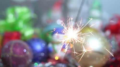 Sparkler Burning with Holiday Ornaments and Gifts