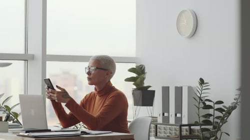 Beautiful Business Lady Using Smartphone in Modern Office