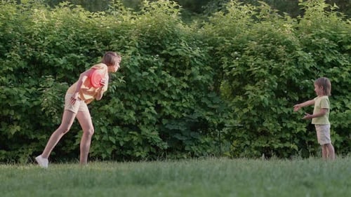Woman and Child Playing Disc in Grassy Yard