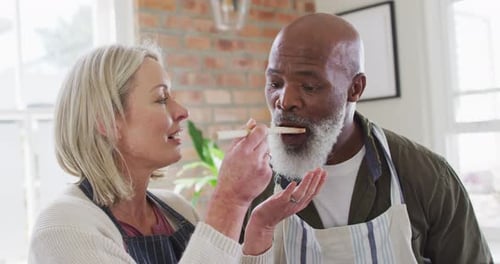 Woman Feeds Man Food in Kitchen
