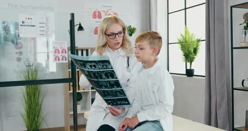 Doctor Showing X-Ray to Young Patient in Office