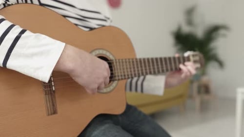 Close Up Young Man Hands Playing the Guitar While Relaxing at Home