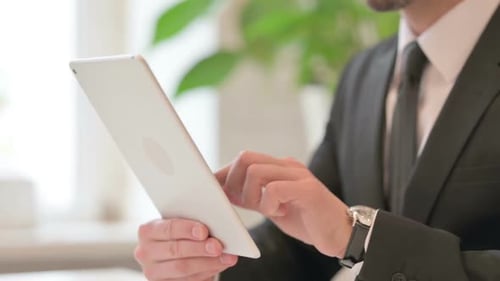 Close-up das mãos do empresário de meia idade trabalhando no tablet