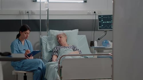 Nurse Taking Notes with Senior Patient in Hospital
