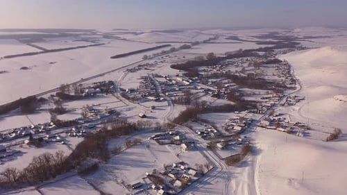 Aerial View of a Winter Village in a Hilly Area