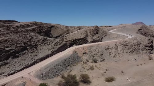 SUVs driving on a dusty road from the mountains in the desert region, Namibia