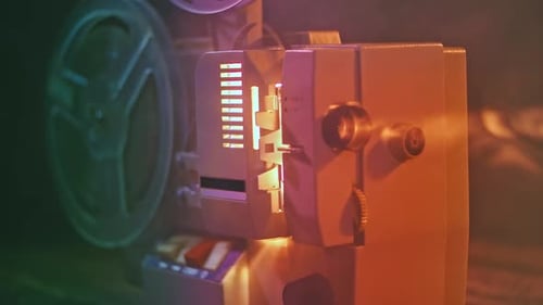 Vintage Film Projector Emitting Bright Light in Dark Room