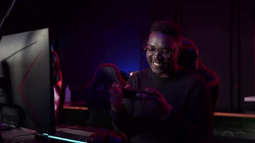 In the Game Club a Black Guy Plays an Online Game on a Smartphone Wins and is Happy