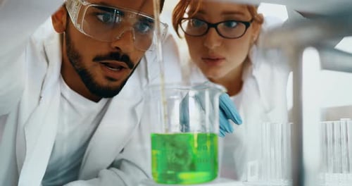Scientists Analyzing Green Liquid in a Beaker