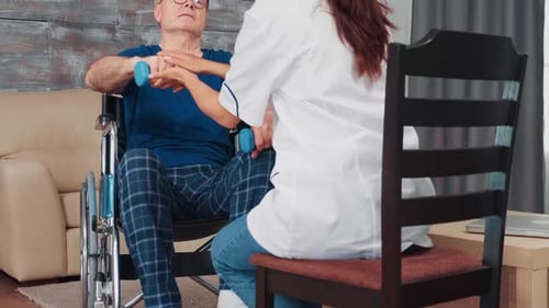 Physical Therapist Assisting Senior Man with Dumbbell Exercise