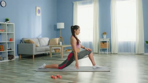 Woman Stretching on Exercise Mat in Living Room