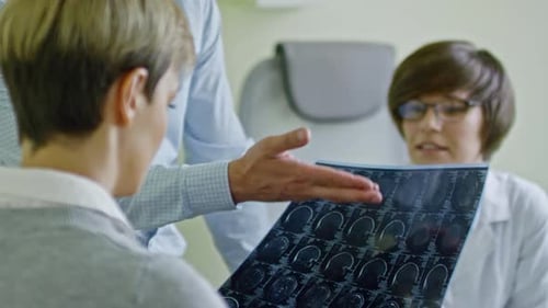 Doctor Explains X-Ray to Patients in Medical Office