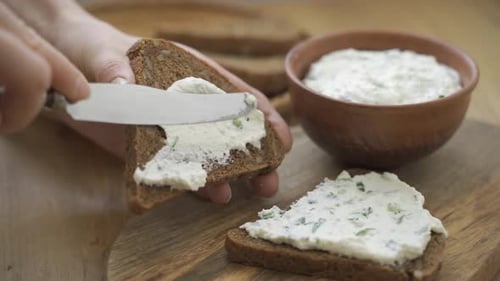 Cream Cheese Being Spread on Brown Toast