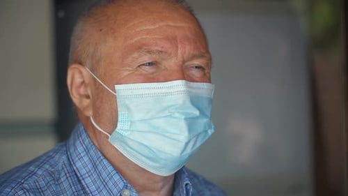 Man Wearing a Disposable Face Mask Close Up