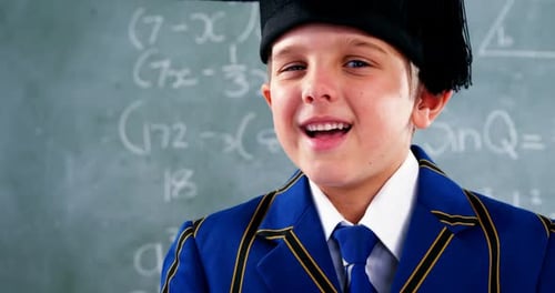 Smiling Boy in Graduation Cap in Classroom