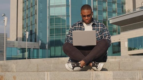 Young Man Using Laptop on Urban Steps