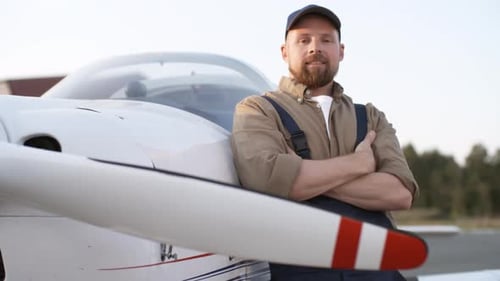 Confident Man Posing Next to a Small Airplane
