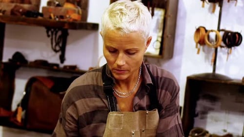 Woman Crafts Leather Product in Workshop