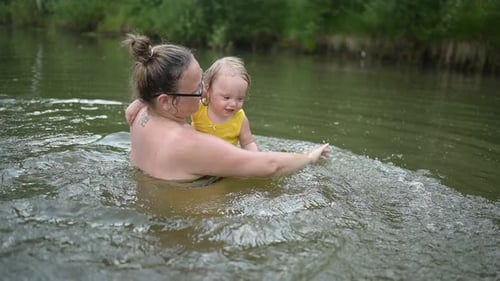 Woman and Child Play in River Water