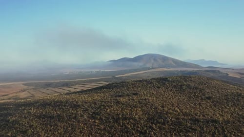 Aerial Shot with Clear Skies and Background and Lush Forest in Foreground