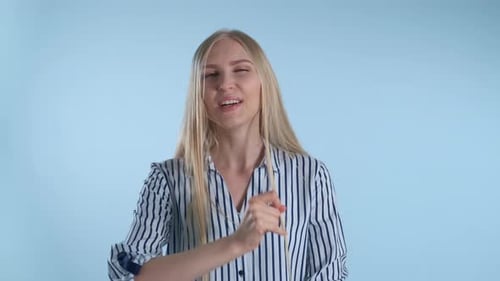 Smiling Woman Makes OK Sign in Studio Setting