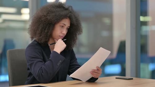 Young Woman Reviews Documents in Modern Office