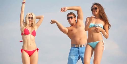 Happy Young Adults Dancing on a Sunny Beach