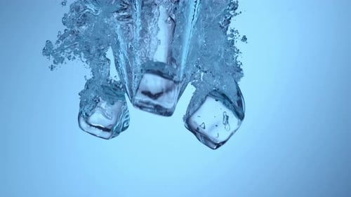 Ice Cubes Falling into Water with Bubbles