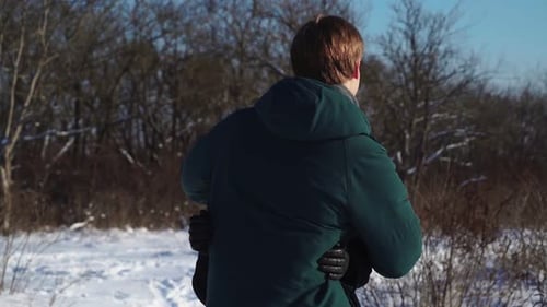 Liebende stehen und umarmen sich im Winterwald