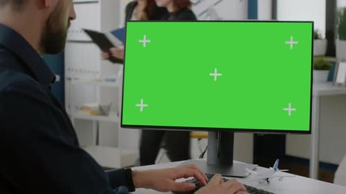 Close Up of Man Typing on Keyboard with Green Screen on Monitor