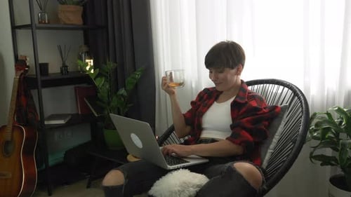 Stylish woman freelancer is working on laptop computer at home office. Education and study at home