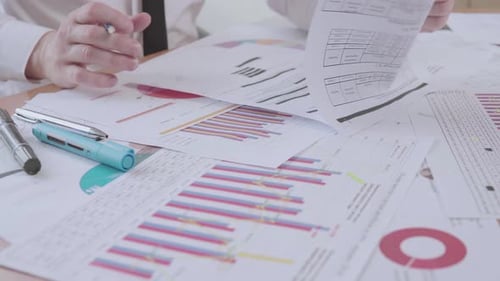 Businessman works with charts in the office at the table and signs documents
