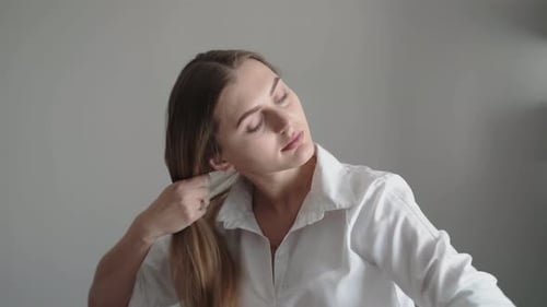Woman Brushing Long Blonde Hair in Home