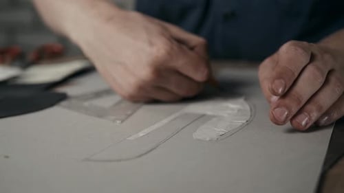 Hands Drawing Around Template With Pencil