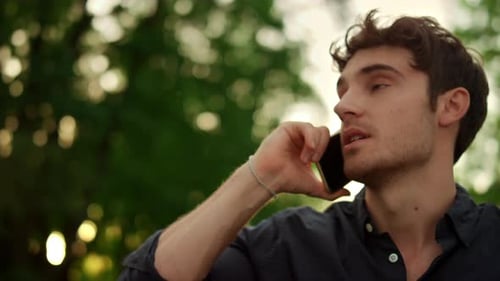 Young Man Talking on Smart Phone Outdoors