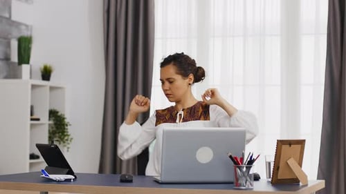Woman Stretching at Desk in Home Office