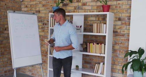 Man Explains Math Equations on Whiteboard at Home