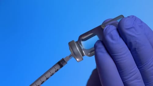 Arzt oder Krankenschwester wählt den Impfstoff in einer Spritze