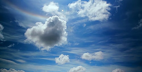 Clouds Float in Blue Sky with Rainbow