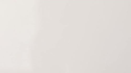 Golden Capsules Falling Against White Background