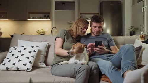 Couple Relaxing on Couch with Dog and Phone