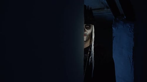 Sinister Man with Halloween Skeleton Makeup Slowly Appears From Dark Corner with Frightening Smile