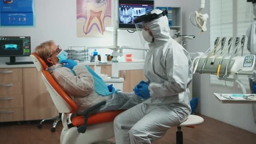 Dentist Consults Patient in Full Protective Gear