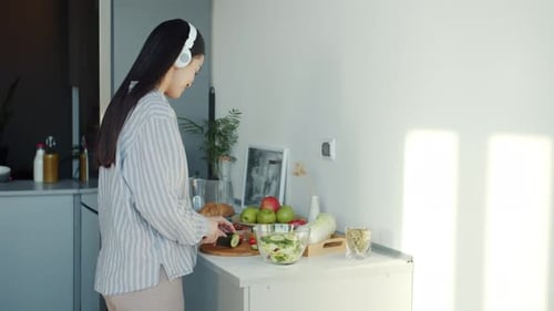 Woman Cutting Vegetables in Kitchen at Home