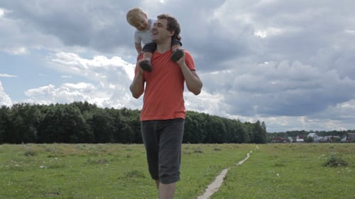 Father and Child Walking Together in Field