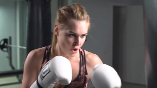 Starke Frau trainiert die Unebenheiten beim Boxtraining. Zeitlupe