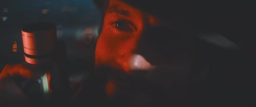 Close up of man looking into camera holding vintage camera