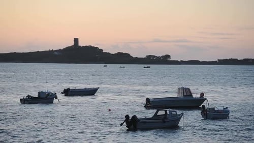 Small Fishing Boats Anchored On The Calm Ocean In St. Peter Port, Guernsey, Channel Islands, UK Duri