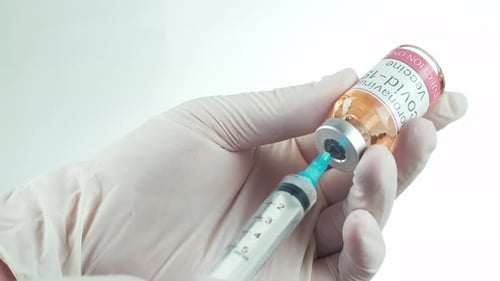 Gloved Hand Draws Vaccine into Syringe from Vial